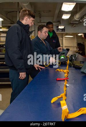 Aircrew Survival Equipmentman Nathan Rios, Mitte, trainiert Airman Carlos Marbury und Airman James Phillips, wie man eine Sitzschale an Bord des Flugzeugträgers USS George H.W. inspiziert Buchse. GHWB bietet der nationalen Kommandobehörde flexible, anpassungsfähige Kriegskampfkapazitäten durch die Trägerstreikgruppe, die maritime Stabilität und Sicherheit aufrechterhält, um den Zugang zu gewährleisten, Aggressionen abzuschrecken und die Interessen der USA, der Alliierten und der Partner zu verteidigen. (USA Navy Foto von Mass Communication Specialist Seaman Ryan Colosanti) Stockfoto