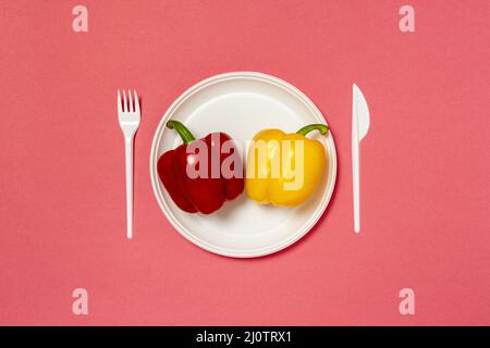Rote und gelbe Paprika auf einem weißen Teller Stockfoto