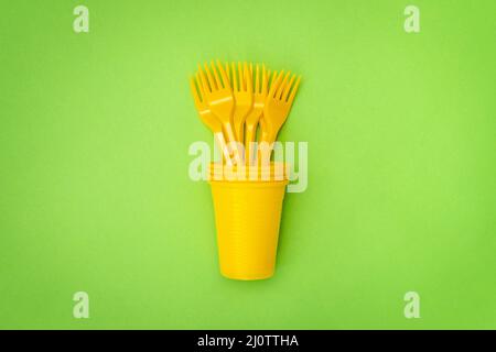 Gelber Kunststoffbecher mit Einweggabeln Stockfoto