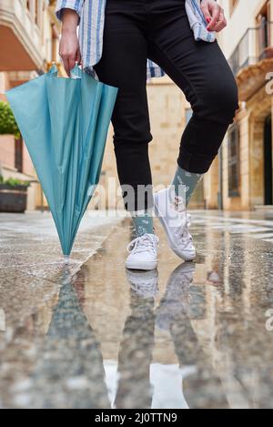 Frau mit Regenschirm, die während des Regens auf der Stadtstraße steht Stockfoto