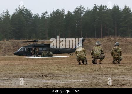 Luftangriffslehrer und Studenten führen Schlingentraglasoperationen mit UH-60 Blackhawk-Hubschraubern durch, die dem Bataillon 1st, dem Aviation Regiment 214th und dem Combat AVN 12th zugeordnet sind. Brigade, während des Luftansturzkurses der US-Armee im Trainingsgebiet Grafenwoehr, Deutschland, 27. Januar 2022. Das Combined Arms Training Center des Army Training Command 7th sponserte den zehntägigen Flugkurs, der von Ausbildern des Warrior Training Center der Army National Guard in Fort Benning, Georgia, angeboten wurde. Der Kurs schult Soldaten bei Luftangriffen, Schleuderbelastungen und Abseilen, um die Nutzung von h zu maximieren Stockfoto