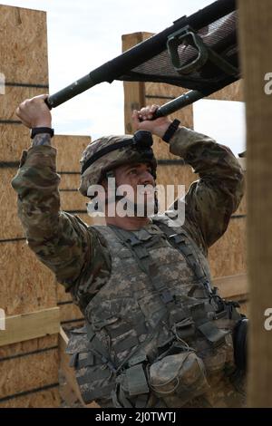 US Army Sgt. Ethan Hart, der New Yorker Nationalgarde zugewiesen wurde, nimmt einen Wurf mit einer Schaufensterpuppe in sich auf, um über die Holzwand zu übertragen, als Ausnahme von dem Mystery Event, das ein Hindernisparcours in Fort Hood, Texas, ist, 26. Januar 2022, Zweiundzwanzig Zweisoldatenteams aus der ganzen Welt reisten nach Texas, um im Finale teilzunehmen und den Titel „der beste Medic der Armee“ zu erhalten. Der Wettbewerb ist ein 72-stündiger, mühsamer Test der körperlichen und geistigen Fähigkeiten der Teams. (USA Armee-Foto von SPC. Bradley McKinley) Stockfoto