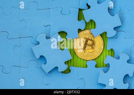 Puzzle mit goldenem Bitcoin darunter Stockfoto