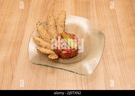 Beef Tartar ist ein Gericht aus rohem Hackfleisch. Es wird in der Regel mit sehr fein gehackten Zwiebeln, Kapern und verschiedenen Zutaten, manchmal einem Ei, serviert Stockfoto