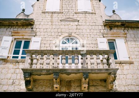 Hausfassade mit Fensterläden, Dachboden und Steinbalkon Stockfoto