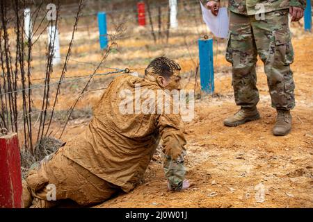 Personal Sgt. Andrew Barnett, 2. Brigade, 98. Training Division (Initial Entry Training), kriecht am 28. Januar 2022 im Hindernisparcours aus dem Schlamm als Teil des 2022 Best Warrior Competition der 98. Training Division in Fort Benning, Georgia. Der Best Warrior Competition würdigt Soldaten, die sich für die Werte der Armee einsetzen, den Warrior Ethos verkörpern und die Macht der Zukunft repräsentieren. (USA Army Reserve Foto von Sgt. Jeffery Harris) Stockfoto