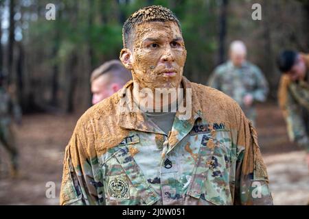 Personal Sgt. Andrew Barnett, 2. Brigade, 98. Training Division (Initial Entry Training), nachdem er am 28. Januar 2022 im Hindernisparcours im Rahmen des 2022 Best Warrior Competition der 98. Training Division in Fort Benning, Georgia, aus dem Schlamm gekrochen war. Der Best Warrior Competition würdigt Soldaten, die sich für die Werte der Armee einsetzen, den Warrior Ethos verkörpern und die Macht der Zukunft repräsentieren. (USA Army Reserve Foto von Sgt. Jeffery Harris) Stockfoto