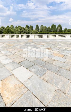 Außen mit altem grauen Steinfußboden. Vintage strukturiertes Pflaster und blauer Himmel im Hintergrund. Stockfoto