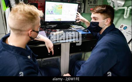 PHILIPPINISCHES MEER (Jan 29, 2022) Aerographer’s Mate Airman Apprentice William Breaulauer, rechts, aus Chicago, und Aerographer’s Mate 3. Class Brandyn Taylor, links, aus Dothan, Al., Verfolgen Sie das Wetter während der bilateralen Trainingsübung Ship Anti-Submarine Warfare Readiness Effectiveness Measuring (SHAREM) mit der Japan Maritime Self Defense Force.Fitzgerald ist auf einem geplanten Einsatz im US 7.-Flottenbereich, um die Interoperabilität mit Allianzen und Partnerschaften zu verbessern und gleichzeitig als einsatzbereite Kraft zur Unterstützung von zu dienen Eine freie und offene Region im Indo-Pazifik-Raum. (USA Navy Foto von Stockfoto