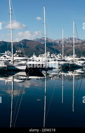 Segelyachten liegen auf dem Pier mit den Bergen im Hintergrund. Porto, Montenegro Stockfoto