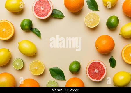 Flaches Lay von Zitrusfrüchten wie Limette, Orange und Zitrone mit Zitronenbaumblättern auf hellem Hintergrund, was einen Rahmen macht. Platz für gesunden Text concep Stockfoto