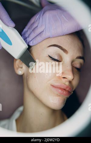 Frau, die eine Reinigungstherapie mit einem professionellen Ultraschallgerät im Kosmetikbad Cosmetology erhält Stockfoto