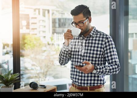 In seiner Pause in Verbindung bleiben. Aufnahme eines jungen Geschäftsmannes, der sein Handy benutzte, während er Kaffee getrunken hatte. Stockfoto