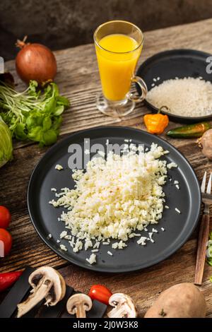 Reis auf schwarzem Teller um Gemüse garnieren Stockfoto