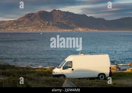 Wohnmobil Wohnmobil mit Solarzellen Blick auf eine Meereslandschaft mit Bergen Leben van Leben in Galiza, Spanien Stockfoto