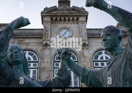 Statue der traditionellen Viana do Castelo Tänzer tanzen mit Bahnhof historischen Gebäude auf dem Hintergrund, in Portugal Stockfoto