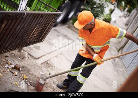 Die Straßen von Müll befreien. Eine abgeschnittene Aufnahme eines Müllsammler, der den Bürgersteig fegen soll. Stockfoto