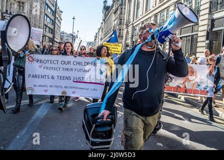 Protest gegen die Impfung von Kindern für Covid 19, begleitet von Anti-Vaxxern. Weißer Mann, der durch das Megaphon schreit, mit Banner Stockfoto