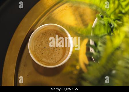Aromatischer, duftender, frisch gebrühter Cappuccino oder Latte mit Schaumstoff, serviert in einer Tasse auf dem Kaffeetisch Stockfoto