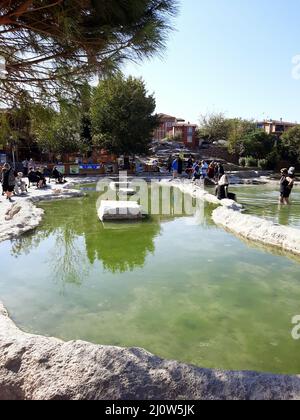 Türkei, Denizli - 10.05.2021: Menschen an den roten Quellen Karahayit ist ein separates Quellwasser mit einer einzigartigen Mineralienkombination. Stockfoto