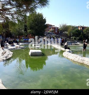 Türkei, Denizli - 10.05.2021: Menschen an den roten Quellen Karahayit ist ein separates Quellwasser mit einer einzigartigen Mineralienkombination. Stockfoto