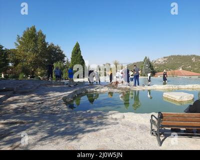 Türkei, Denizli - 10.05.2021: Menschen an den roten Quellen Karahayit ist ein separates Quellwasser mit einer einzigartigen Mineralienkombination. Stockfoto