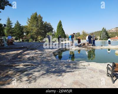 Türkei, Denizli - 10.05.2021: Menschen an den roten Quellen Karahayit ist ein separates Quellwasser mit einer einzigartigen Mineralienkombination. Stockfoto