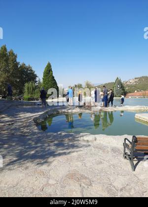 Türkei, Denizli - 10.05.2021: Menschen an den roten Quellen Karahayit ist ein separates Quellwasser mit einer einzigartigen Mineralienkombination. Stockfoto