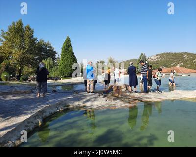 Türkei, Denizli - 10.05.2021: Menschen an den roten Quellen Karahayit ist ein separates Quellwasser mit einer einzigartigen Mineralienkombination. Stockfoto