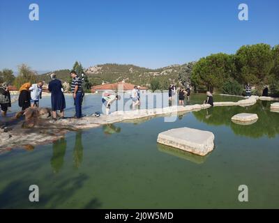 Türkei, Denizli - 10.05.2021: Menschen an den roten Quellen Karahayit ist ein separates Quellwasser mit einer einzigartigen Mineralienkombination. Stockfoto