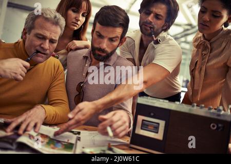 Was ist mit dem einen. Eine Gruppe von 70s Designern, die im Büro zusammenarbeiten. Stockfoto