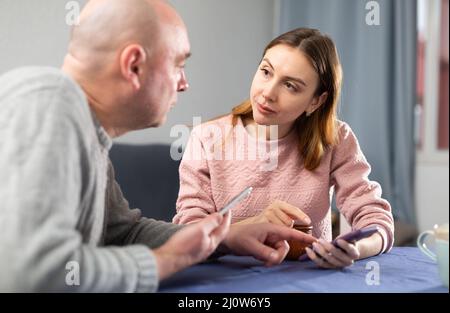 Ehefrau und Ehemann mit Smartphones unterhalten sich Stockfoto