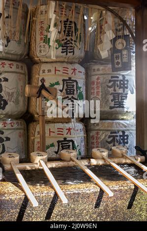 Ein rituelles Bambuswaschbecken (Tsukubai) mit Sake-Fässern am Nishiki-Tenmangu-Schrein. Kyoto. Japan Stockfoto