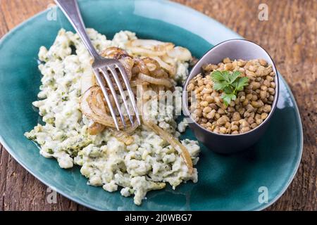 Bayerischer Käsespätzle mit braunen Linsen Stockfoto