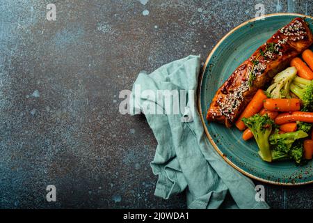 Gegrilltes Lachsfiletsteak in Teriyaki-Sauce mit gebratenem Gemüse Karotten und Brokkoli Stockfoto
