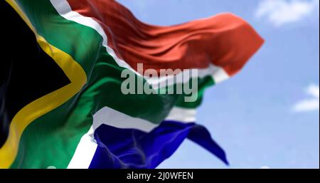 Detaillierte Nahaufnahme der Nationalflagge Südafrikas, die an einem klaren Tag im Wind winkt Stockfoto