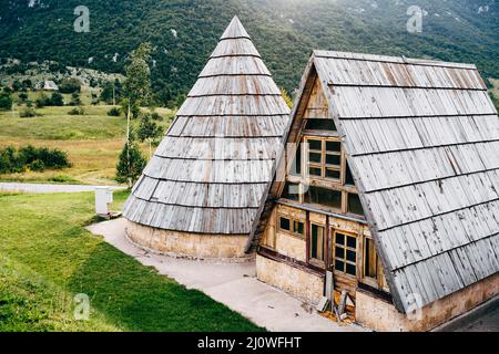 Dreieckiges Haus neben einem konischen auf einem grünen Rasen. Montenegro Stockfoto