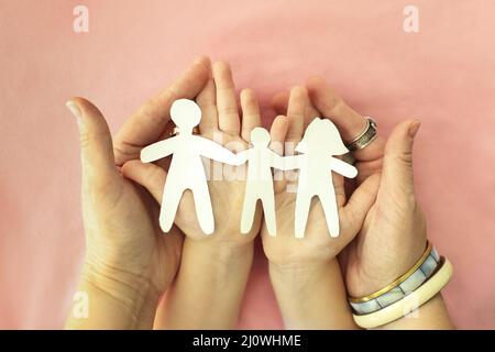 Eltern und Kind halten Familienpapier in den Händen. Feiern des Internationalen Tages der Familien Stockfoto