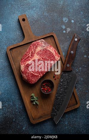 Rohes Fleisch Rindfleisch marmoriertes Prime Cut Steak Ribeye auf Holzschneidebrett Stockfoto