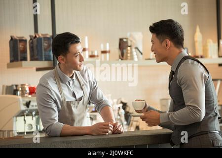 Ein Barista, der einen Gast in einem Café bedient Stockfoto