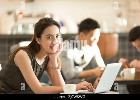 Schöne chinesische Frau arbeitet im Café Stockfoto