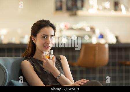Wunderschöne Chinesin, die in der Hotelbar Whiskey trinkt Stockfoto