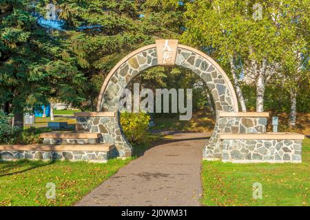 Steinbogen mit chinesischer Inschrift über dem Gang zum Tai Chi Park bei Prince Arthurs Landing in Thunder Bay, Ontario. Stockfoto