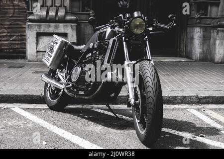 Altes schwarzes Custom Motorrad auf der Straße geparkt Stockfoto