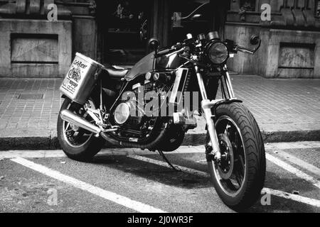 Altes schwarzes Custom Motorrad auf der Straße geparkt Stockfoto