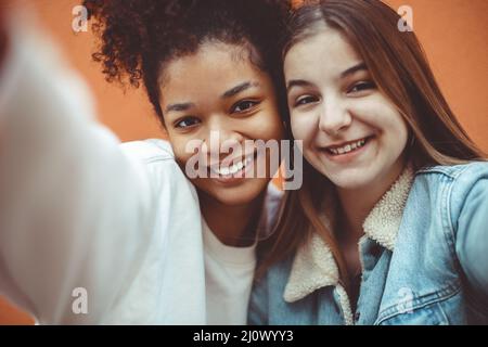 Selbstportrait von zwei fröhlichen Teenagern verschiedener Rassen, die Selfie machen und Freundschaft genießen Stockfoto