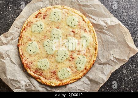 Fast Food, gebackene Tiefkühlpizza mit vier Käsesorten und Pizza mit Mozzarella-Käse, Tomaten und Pesto. Bereit zum Essen Stockfoto