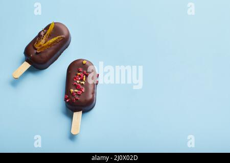 Mousse-Dessert mit Fruchtaromen in Form von Eiscreme auf blauem Hintergrund. Stockfoto