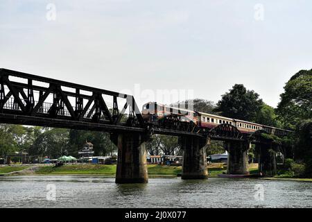 Kanchanaburi, Thailand. 21.. Februar 2022. Ein Personenzug überquert die Brücke am Fluss Kwai, etwa 140 km westlich der Hauptstadt Bangkok. Gebaut von den Japanern, um eine Route zwischen Thailand und Myanmar zu schaffen, die als Todesbahn bekannt ist. Über 60.000 alliierte Gefangene bauten die Brücke während der japanischen Besetzung Thailands, 13,000 Gefangene kamen während des Baus ums Leben. Die im Oktober 1943 fertiggestellte Eisenbahnlinie verbindet die südliche Hauptlinie Thailands von Bangkok aus. (Bild: © Paul Lakatos/SOPA Images via ZUMA Press Wire) Stockfoto
