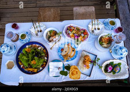 Frühstückstisch in den Bergen von Thailand Chiang Mai, Holztisch serviert festlichen Tisch mit hausgemachten Speisen und Getränken, frisches Obst Stockfoto